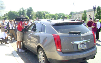 a driverless cadilac in front of capitol hill surrounded by people